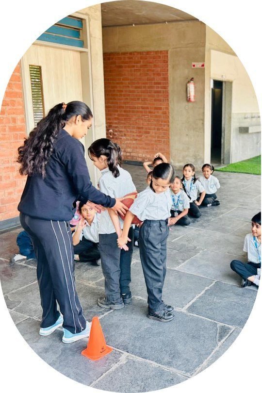 A teacher leading a group of young students outdoors